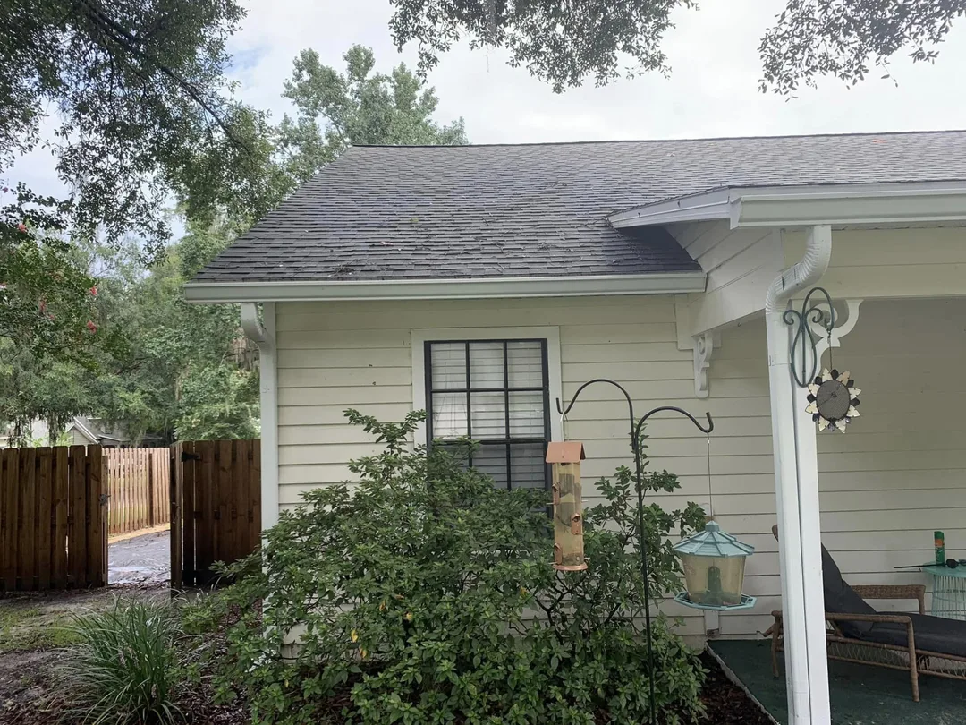 Home with a newly installed gray asphalt shingle roof, viewed from the backyard