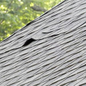 A roof showing signs in needs replacement because of curling shingles.