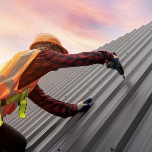 A man installing metal roofing.