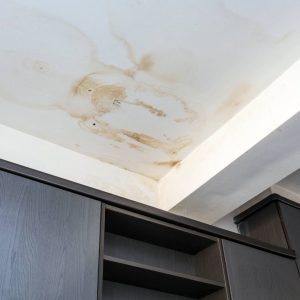A ceiling with a water stain from a leaky roof.